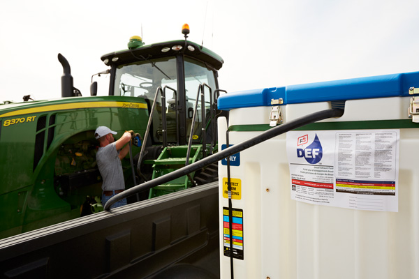 Farmer filling tractor from bulk diesel exhaust fluid tank